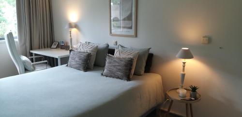 a bedroom with a bed with pillows and a lamp at logies Huis Liselotte in Genk