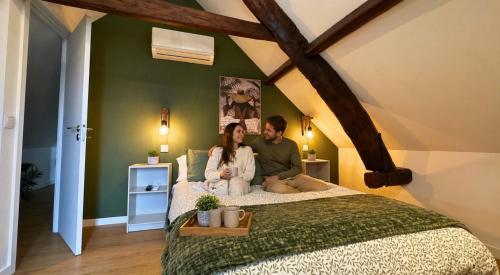 a man and a woman sitting on a bed at Lourença Stays - Quinta Lourença in Vilar