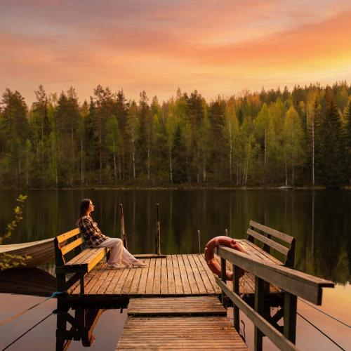 two people sitting on a dock on a lake at Kyyrönkaita in Kyyrö