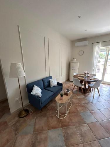 a living room with a blue couch and a table at DIMORA REALE - Charming House Caserta in Casagiove