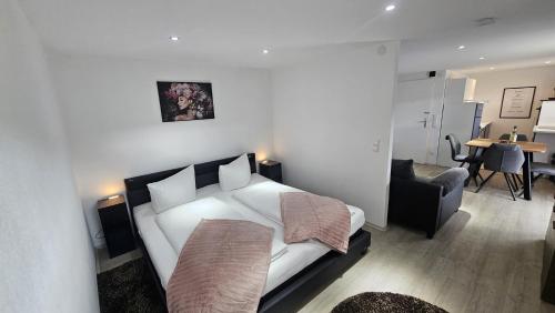 a bedroom with a bed and a chair and a table at Schwarzwald Lodge Schonach in Schonach