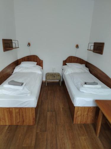 two beds in a room with wooden floors at Solar Club Apartman Sopron in Sopron