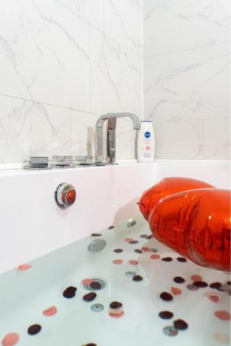 an orange bath tub with a faucet in a bathroom at Évasion étoilée in Corbeil-Essonnes