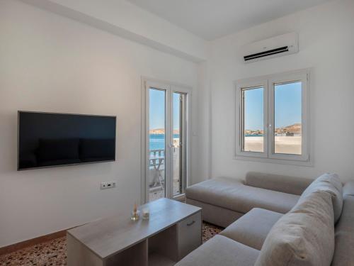 a living room with a couch and a tv at Paroikia Sunset in Kampos Paros