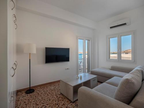 a living room with a couch and a tv at Paroikia Sunset in Kampos Paros