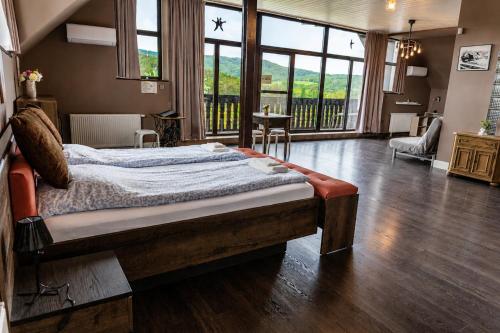a bedroom with a large bed in a room with wood floors at Határtalan Vendégház in Pilisszentiván