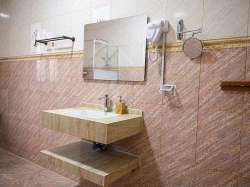 a bathroom with a sink and a shower with a mirror at Saal house in Nizwa