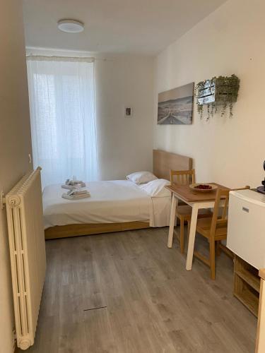 a small bedroom with a bed and a table at Fortezza in Bellinzona