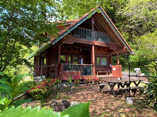 a log cabin with a picnic table in front of it at Sunny Side Cottage in Shimoda