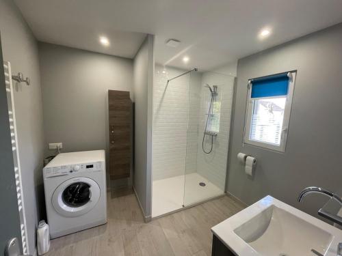 a bathroom with a washing machine and a shower at La ferme Bourguignonne in Saizy