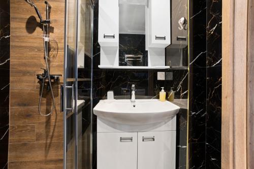 a bathroom with a white sink and a shower at Appartement Moderne 1 à Fréjus in Fréjus