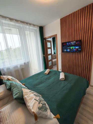 a bedroom with a green bed with two pillows on it at Rubin Verde Residence in Sárvár