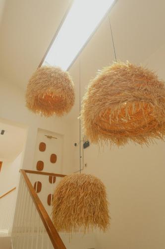 two large hay spheres hanging from a ceiling at Aura Stays L8 in Vagator