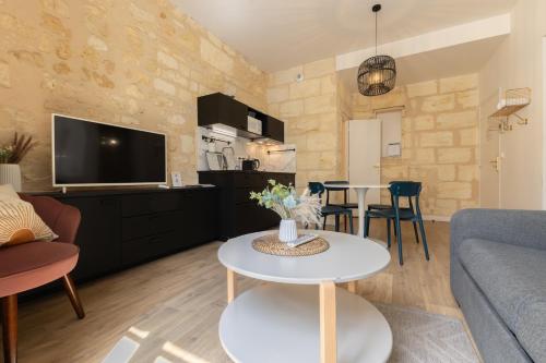 a living room with a couch and a table at Magnifiques Appartements - Face a la Gare in Bordeaux