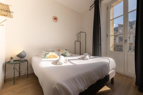 a large white bed in a room with a window at Magnifiques Appartements - Face a la Gare in Bordeaux