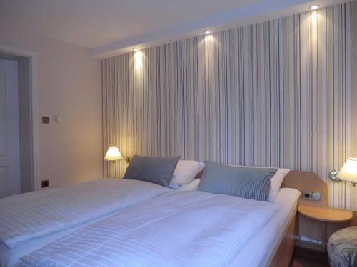 a bedroom with a large white bed with two pillows at Ferienwohnung Graf Knurrhahn in Karlshagen