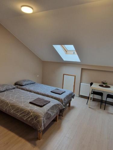 two beds in a room with a skylight at FB Apartamentai in Plungė