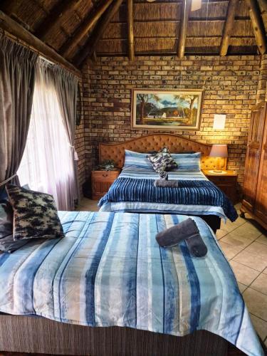 a bedroom with two beds and a brick wall at Big Boma Guest House in Lydenburg
