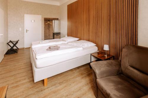 a bedroom with a large bed and a couch at Hotel Ratsstuben Kalbe in Kalbe