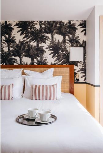 a bed with two cups on a tray on it at Le Château Réal in Saint-Seurin-de-Cadourne