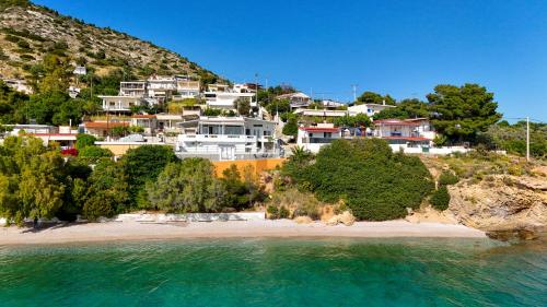 a group of houses on a hill next to a beach at Deep Blue Escape Villa Salamina in Áyios Yeóryios