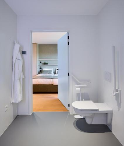 a bathroom with a toilet and a bed in a room at Vakantiewoning Belle Vue in Hooglede