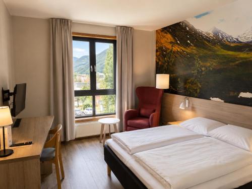a hotel room with a bed and a desk and a window at Haukeland Hotell in Bergen