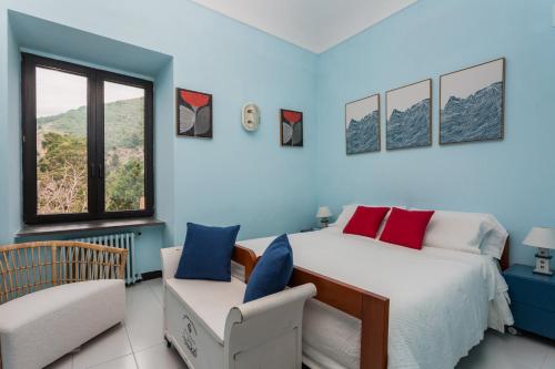 a bedroom with a bed and a chair and a window at Villa Margi in Vico Equense
