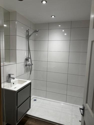 a white bathroom with a sink and a shower at Lingmoor in Windermere