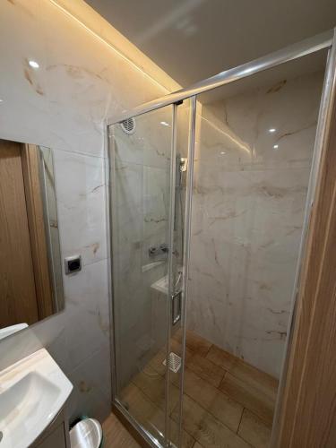 a shower with a glass door in a bathroom at Pensjonat Resident in Krynica Morska