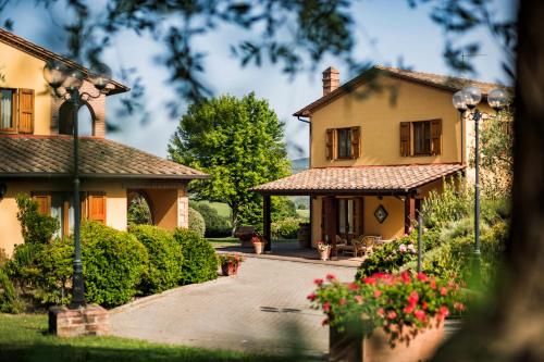 a house with a garden and a driveway at PODERINA DEI POGGI 12, Emma Villas in Castiglione del Lago