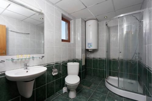 a bathroom with a toilet and a sink and a shower at Vemara Club Villas in Byala
