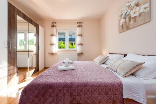 a bedroom with a large bed with a teddy bear on it at Villa Balen ZadarVillas in Lisičići