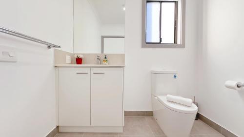 a white bathroom with a toilet and a window at Evergreen 3B Home by Goodlive in Clyde