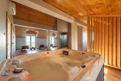 a jacuzzi tub in a room with wooden ceilings at Villa Balen ZadarVillas in Lisičići
