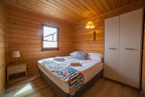 a bedroom with a bed in a wooden cabin at Domki Przewłoka in Przewłoka