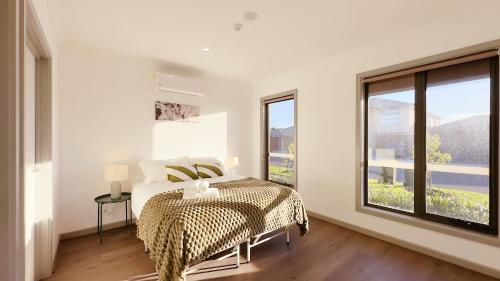 a white bedroom with a bed and a large window at Evergreen 3B Home by Goodlive in Clyde