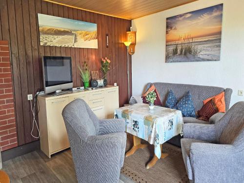 a living room with two chairs and a table with a television at Ferienhaus am Wiesengrund in Sagard