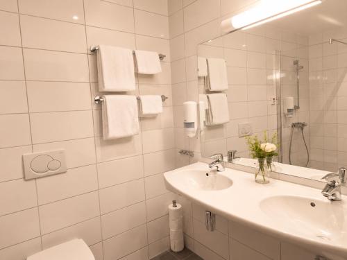 a white bathroom with a sink and a mirror at Haukeland Hotell in Bergen