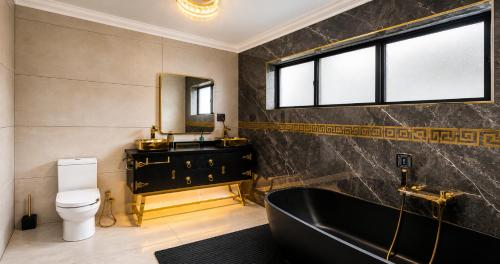 a bathroom with a black tub and a toilet at Bryanston Palms Accommodation in Johannesburg