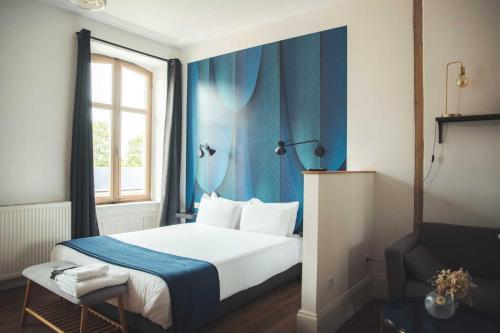 a bedroom with a bed with a blue wall at Le Studio 3 - Route des vins in Rorschwihr