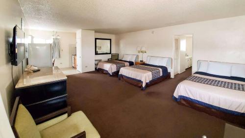 a hotel room with three beds and a sink at Magnuson Hotel Sierra Vista in Sierra Vista