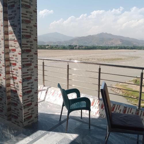 ein Stuhl auf einem Balkon mit Blick auf einen Fluss in der Unterkunft River Breeze Hotel in Mingora