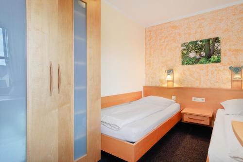 a small bedroom with a bed and a closet at Haus Baden in Hagnau