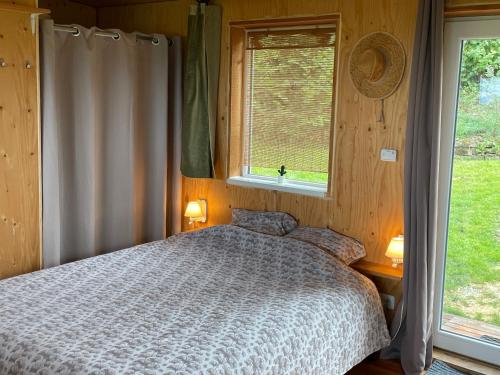 a bedroom with a bed and a window at Chalet panoramique et moderne tout confort in Saizy