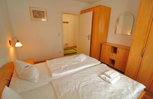a white bed in a room with a mirror at Ferienwohnung Feuerstein in Sassnitz