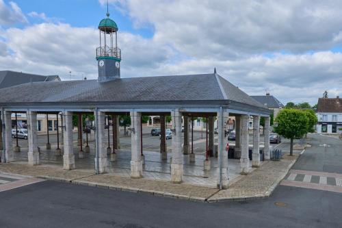 a building with a clock tower on top of it at Hôtel Restaurant Le Plat d'Etain in Brou