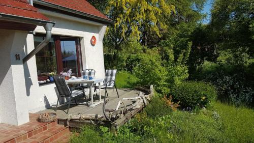 a patio with a table and chairs in a yard at Familienhaus Sonne in Mukran