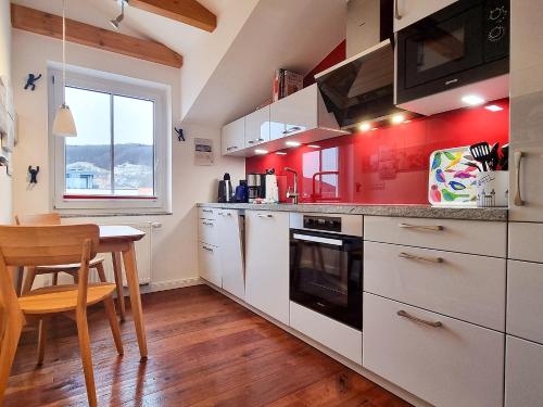 a kitchen with white cabinets and a table and a window at Ferienwohnung Lorenz in Sassnitz