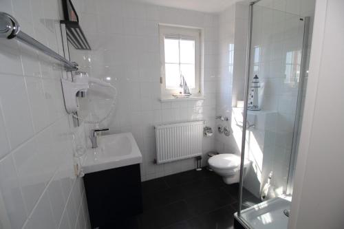 a white bathroom with a sink and a toilet at Ferienwohnung Kranichglück in Neddesitz